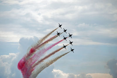 Low angle view of airplanes flying against sky