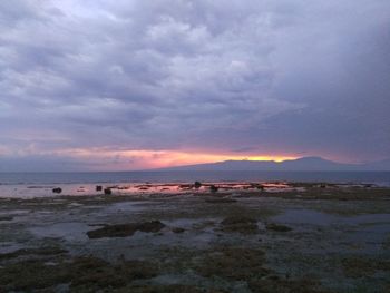 Scenic view of sea against dramatic sky during sunset