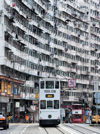 Cars on road by buildings in city