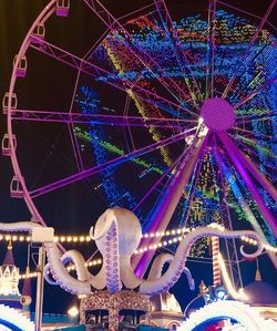 Low angle view of illuminated ferris wheel at night