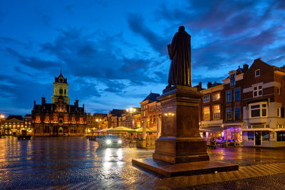 Illuminated buildings against sky at dusk