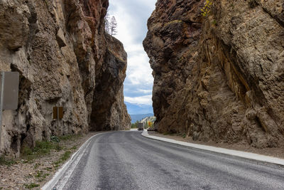 Road amidst rock formation against sky