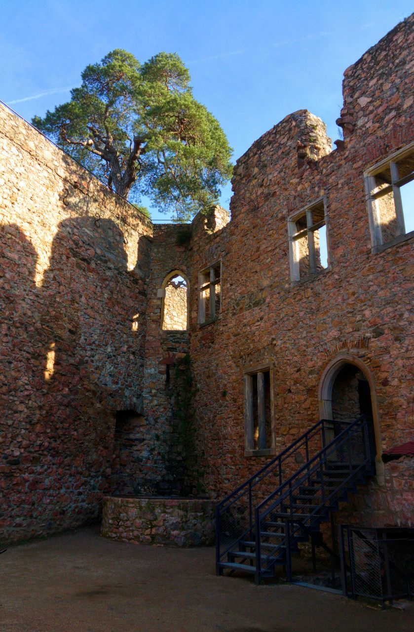 architecture, built structure, building exterior, stone wall, brick wall, window, old, wall - building feature, history, clear sky, low angle view, house, building, sunlight, wall, arch, shadow, residential structure, day, residential building