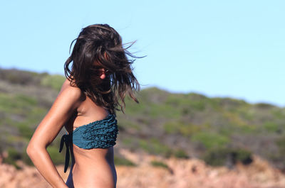 Side view of woman standing against sky