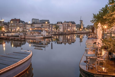 Boats moored in river against buildings in city