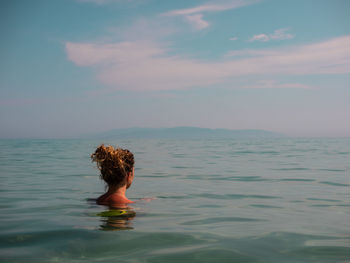 Woman swimming in sea against sky