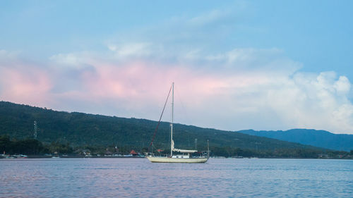 Sailboat on sea against sky during sunset