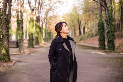 Smiling young woman standing on road