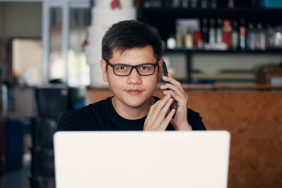 Portrait of man talking over smart phone at home