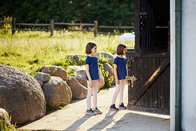 Twin sisters standing at entrance of ranch