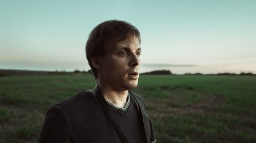 Portrait of young man standing on field