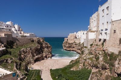 View of built structures against calm blue sea