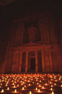 The treasury in petra lit up at night by candle lights.