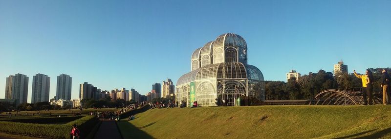 Panoramic view of buildings against clear blue sky