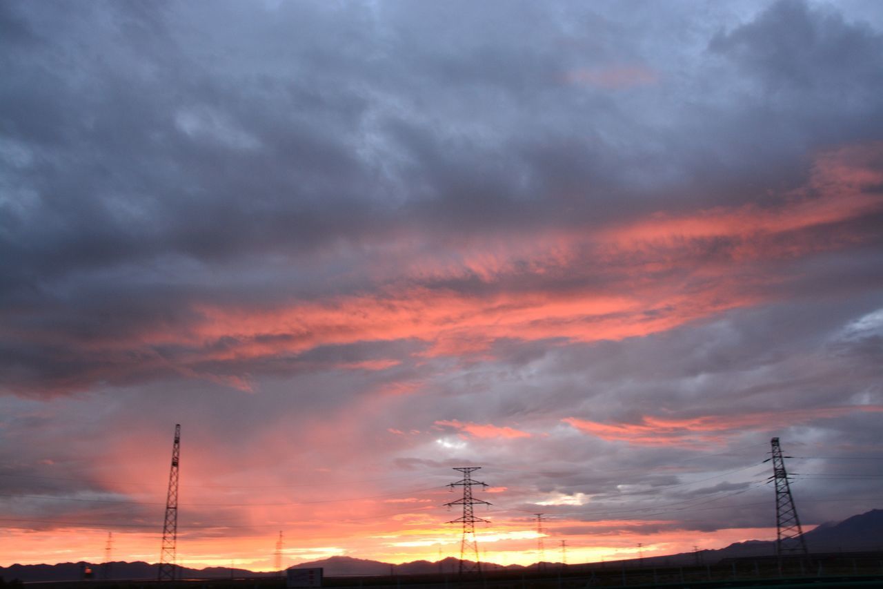 LOW ANGLE VIEW OF SILHOUETTE ELECTRICITY PYLON AGAINST ORANGE SKY