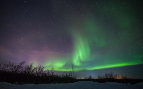 Scenic view of snowcapped field against sky at night