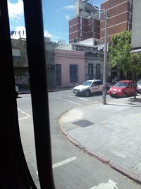 Cars on city street by buildings