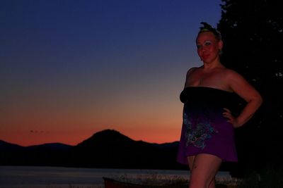 Portrait of woman standing against sky during sunset