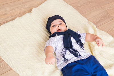 High angle view of baby boy lying on floor at home