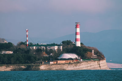 Lighthouse by lake against sky