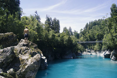 Rear view of man in swimming pool against sky