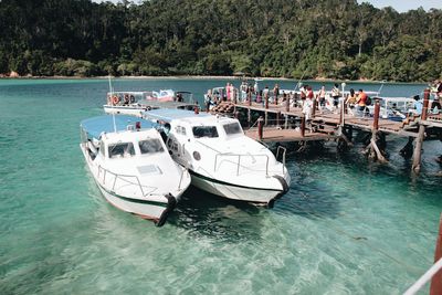 People on boats moored in sea