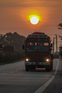 Cars on road against orange sky