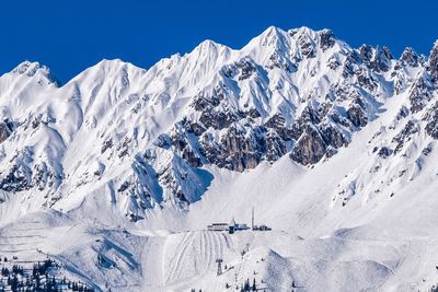 Scenic view of snowcapped mountains against clear blue sky