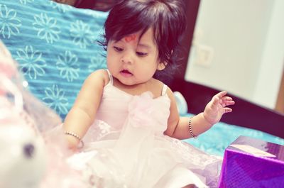 Close-up of girl sitting on bed