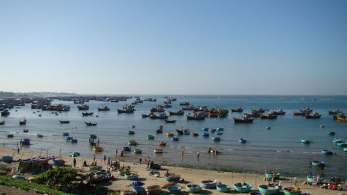 High angle view of people on beach against clear sky