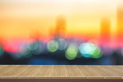 Defocused image of illuminated lights against orange sky