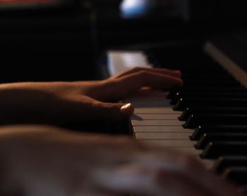 Midsection of girl playing piano