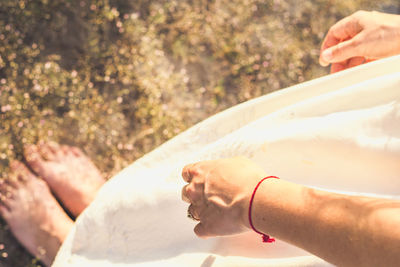 Close up woman in white dress with red thread on wrist concept photo