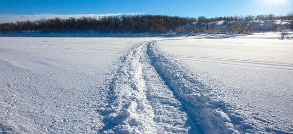 Scenic view of snow covered field against sky