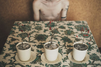 High angle view of woman holding coffee cup on table