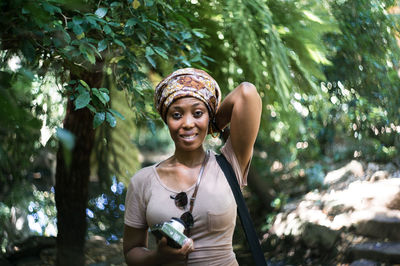 Portrait of smiling young woman in forest