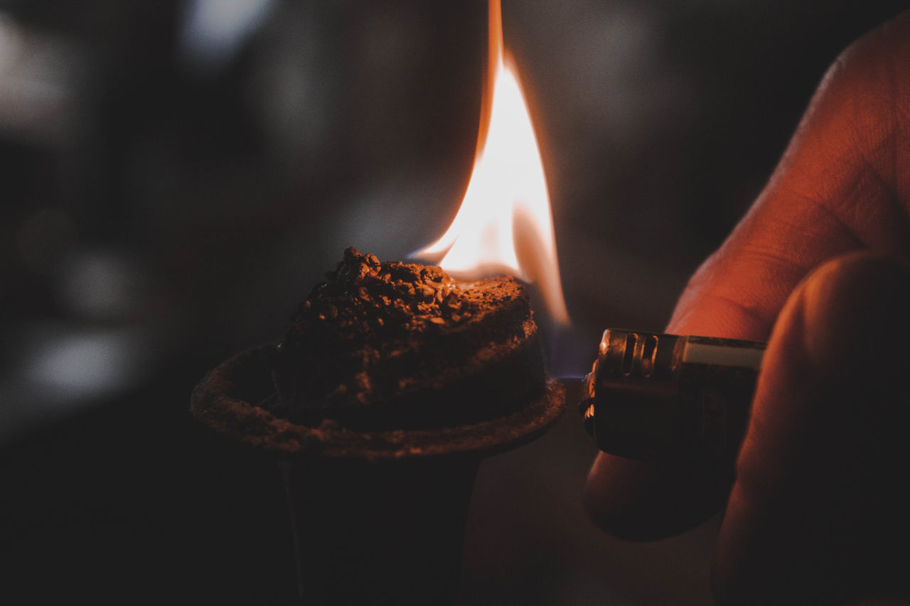 burning, fire, human hand, flame, hand, one person, human body part, heat - temperature, real people, fire - natural phenomenon, holding, close-up, unrecognizable person, sweet food, sweet, candle, dessert, body part, lifestyles, event, finger, temptation, matchstick