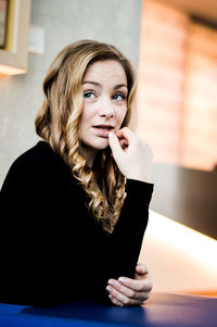 Portrait of young woman sitting at home