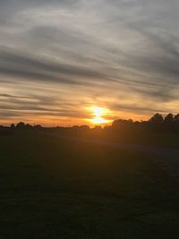 Scenic view of silhouette field against sky during sunset