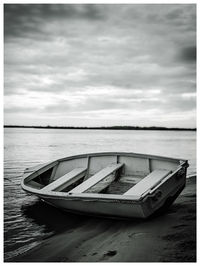 Old boat resting in river under gloomy skies