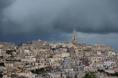 Buildings in city against cloudy sky