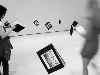 Low angle view of woman photographing on wall