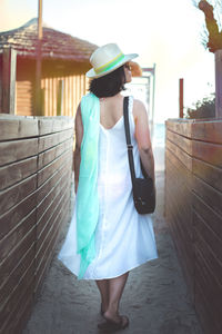 Rear view of woman using mobile phone while standing outdoors