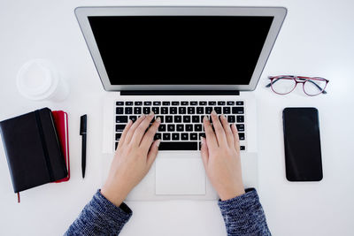 Low section of person using laptop on table