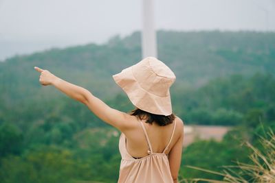 Rear view of woman wearing hat standing outdoors