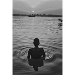 Rear view of man swimming in river