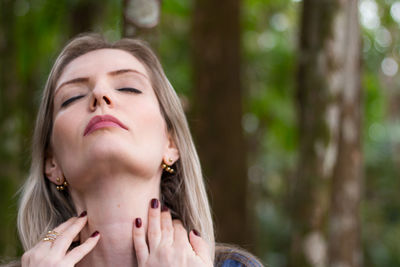 Close-up of beautiful woman against trees