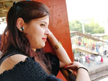 Side view of thoughtful young woman looking away on bridge