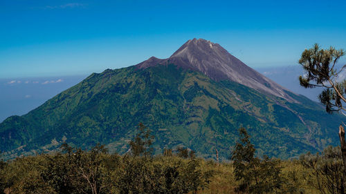 Scenic view of mountains against blue sky