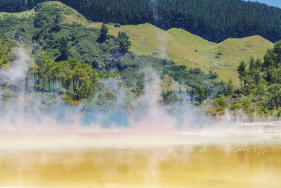 Scenic view of hot spring against mountain